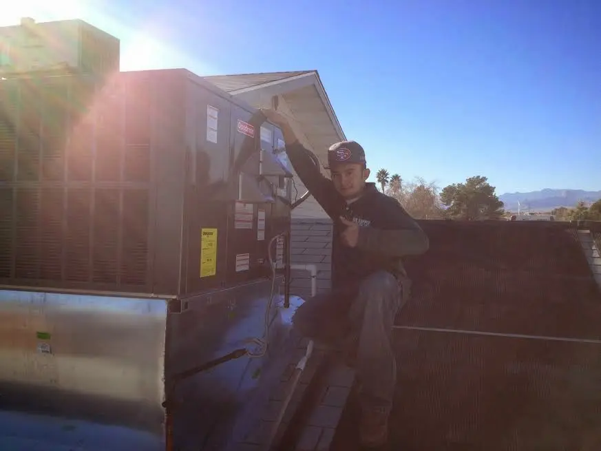 HVAC technician performing AC Tune-Up on a rooftop unit in Lucerne Valley